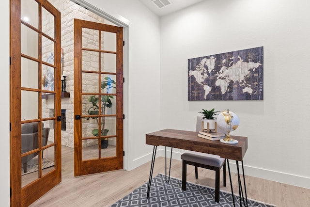 home office with wood-type flooring and french doors