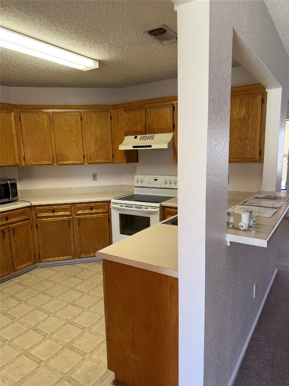 kitchen featuring a textured ceiling, white electric stove, and light colored carpet