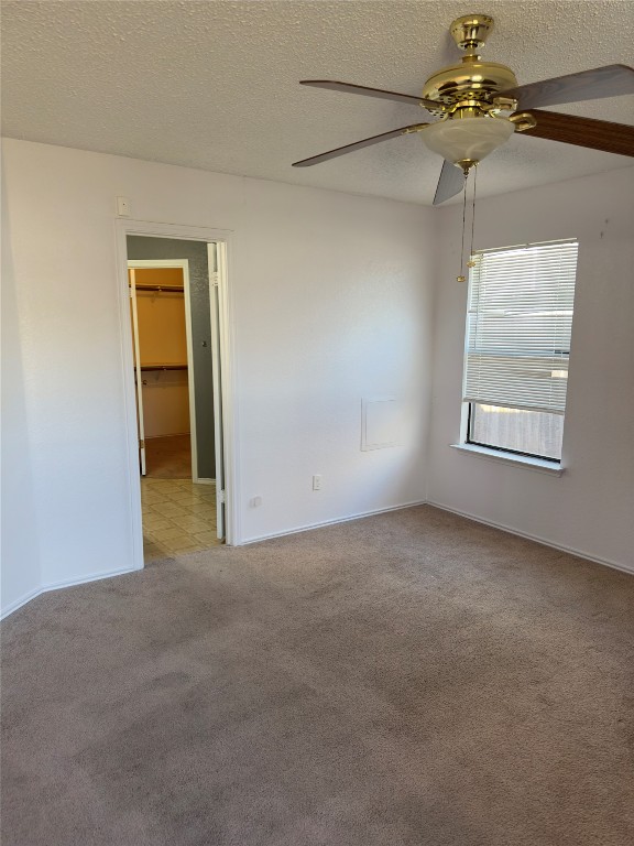 unfurnished room with light carpet, a textured ceiling, and ceiling fan