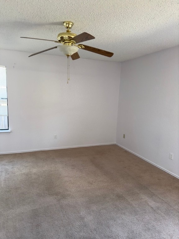 carpeted empty room with ceiling fan and a textured ceiling