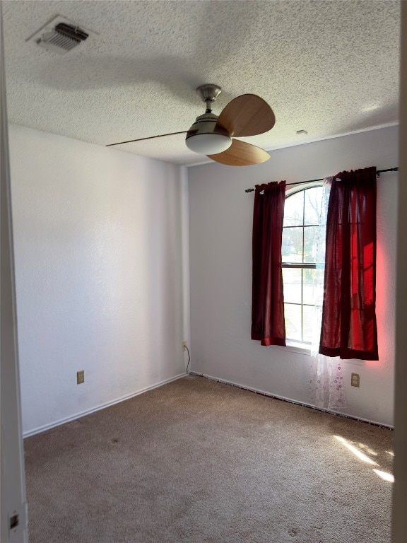 carpeted spare room with a textured ceiling and ceiling fan