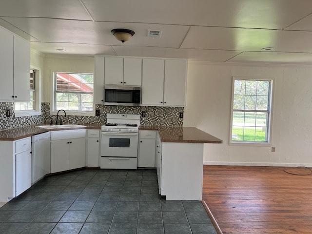 kitchen with white cabinetry, white appliances, and sink