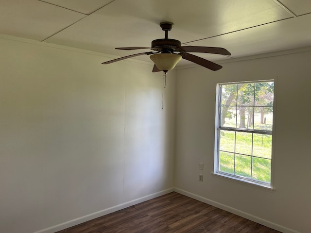 spare room featuring ceiling fan, dark wood-type flooring, and a healthy amount of sunlight