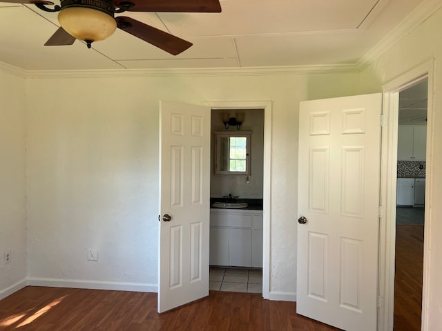 unfurnished bedroom featuring dark hardwood / wood-style floors, ceiling fan, sink, and ornamental molding