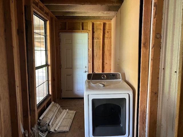 clothes washing area featuring washer / clothes dryer and wooden walls