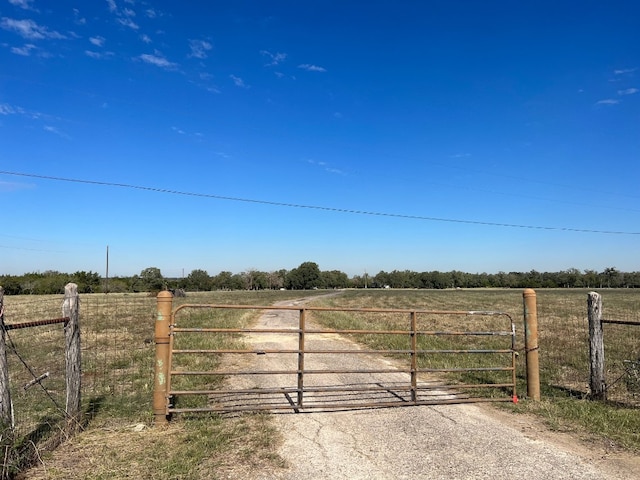 view of gate with a rural view