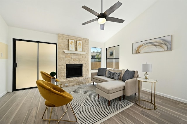 living room featuring ceiling fan, a fireplace, high vaulted ceiling, and wood-type flooring