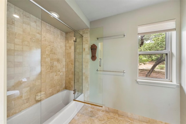 full bath featuring shower / bath combination with glass door and baseboards