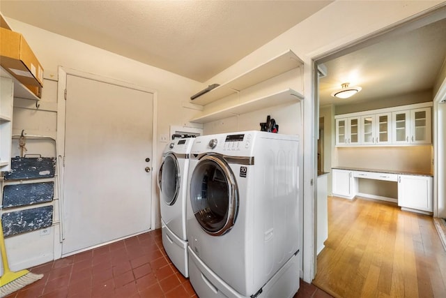 laundry area featuring a textured ceiling, laundry area, washer and clothes dryer, and tile patterned flooring