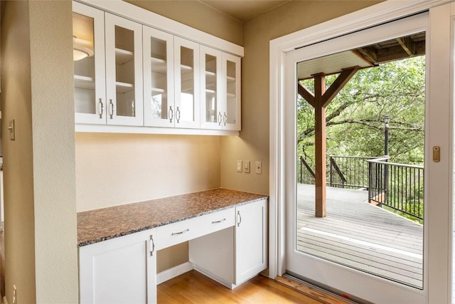 doorway to outside with light wood-type flooring and built in study area