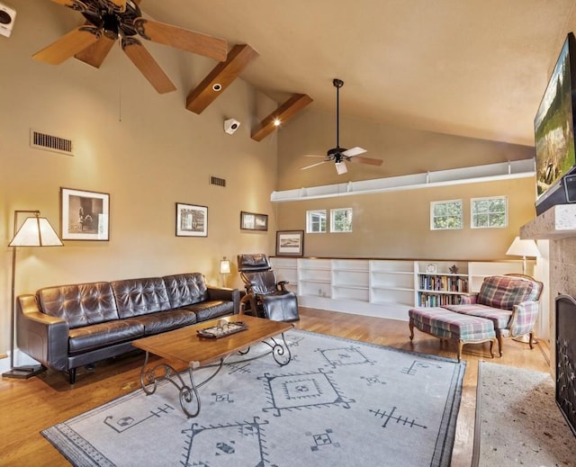 living area featuring visible vents, a fireplace, and wood finished floors