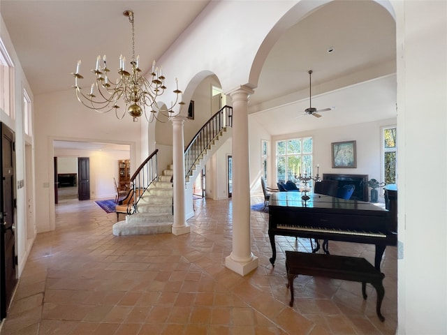 entryway with ornate columns, lofted ceiling, and ceiling fan with notable chandelier