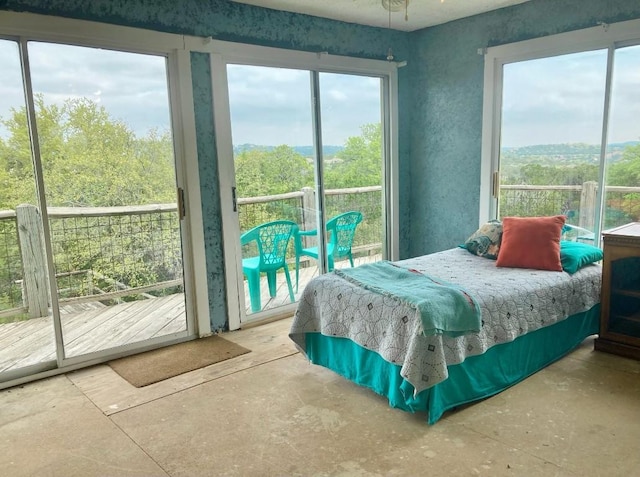 bedroom featuring access to exterior and unfinished concrete flooring