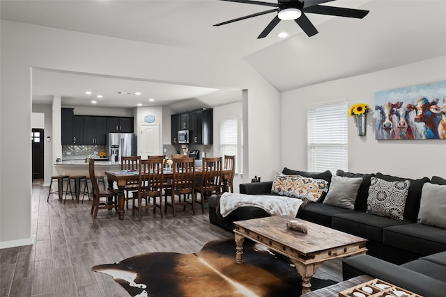 living room with ceiling fan, dark wood-type flooring, and lofted ceiling