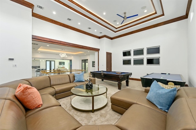 living room featuring ceiling fan, a raised ceiling, ornamental molding, and billiards