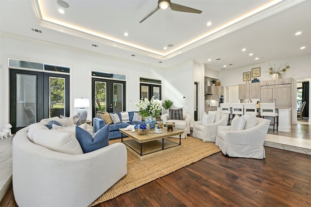 living room with ceiling fan, french doors, dark wood-type flooring, crown molding, and a tray ceiling