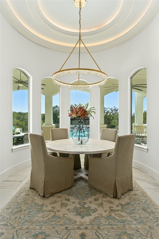 tiled dining space with a raised ceiling