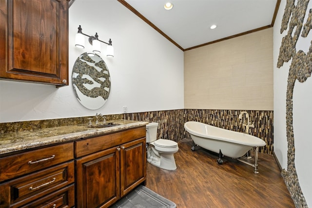 bathroom featuring vanity, crown molding, hardwood / wood-style floors, toilet, and a tub