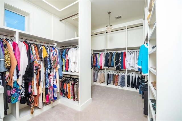 walk in closet with visible vents and carpet