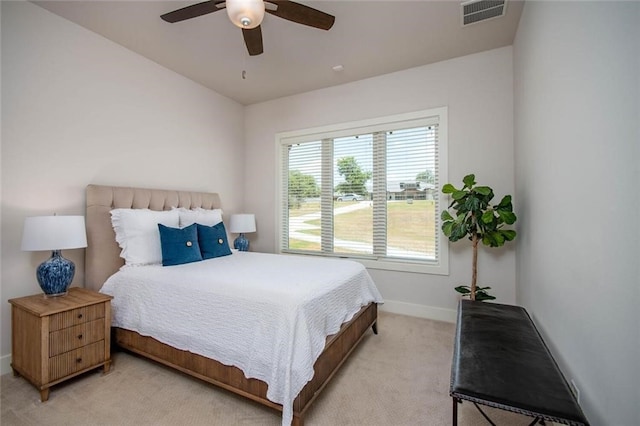 bedroom featuring visible vents, light colored carpet, baseboards, and ceiling fan