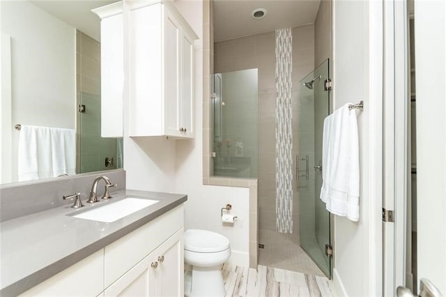 full bathroom featuring vanity, toilet, and a stall shower