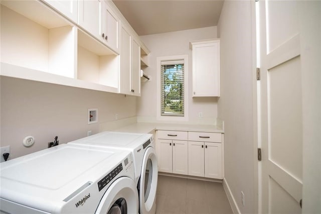 clothes washing area with washer and dryer and cabinet space