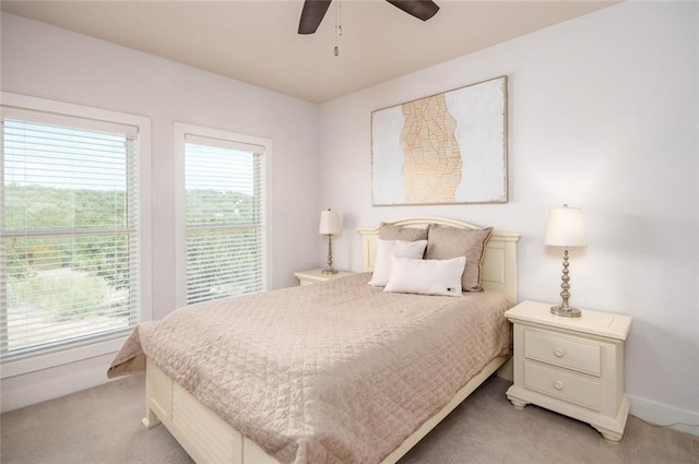 bedroom featuring light colored carpet, baseboards, and ceiling fan