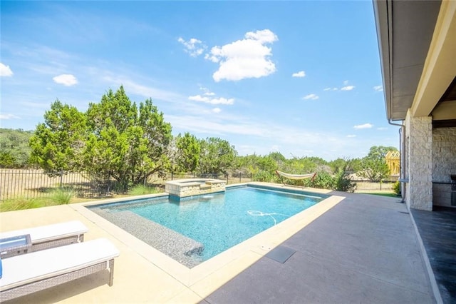 view of swimming pool featuring a patio, a pool with connected hot tub, and fence