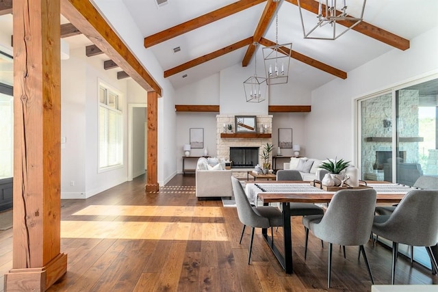 dining area with a notable chandelier, a healthy amount of sunlight, high vaulted ceiling, and hardwood / wood-style floors