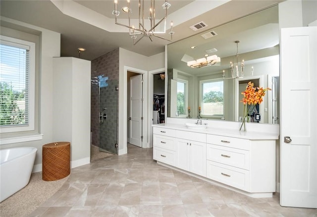 bathroom with visible vents, a stall shower, an inviting chandelier, a soaking tub, and vanity