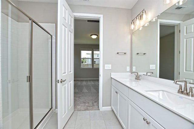 bathroom featuring tile patterned floors, a shower with door, and dual bowl vanity