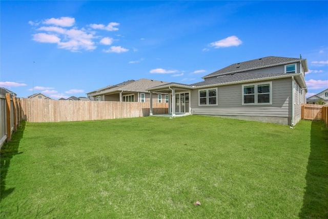 back of property featuring a yard and a fenced backyard