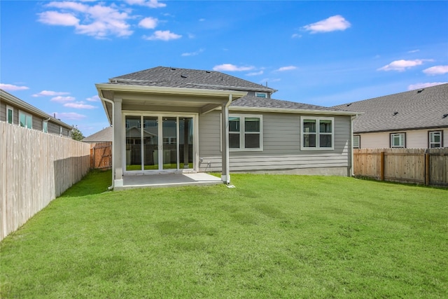 back of property with a yard and a patio area