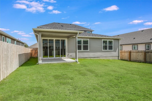 rear view of property with a shingled roof, a fenced backyard, a lawn, and a patio