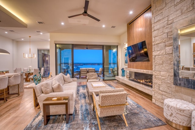 living area with recessed lighting, a fireplace, visible vents, and light wood-style floors