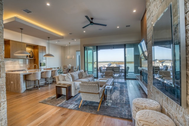 living room with ceiling fan and hardwood / wood-style floors