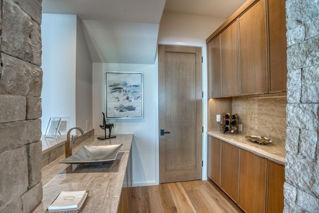 kitchen featuring sink, light hardwood / wood-style floors, and decorative backsplash