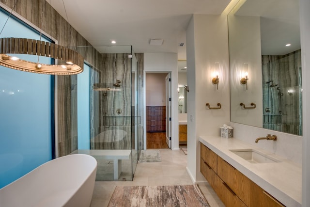 bathroom with independent shower and bath, tile patterned flooring, vanity, and tile walls