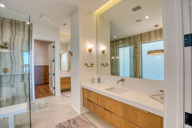 bathroom with vanity, tile patterned flooring, and tiled shower