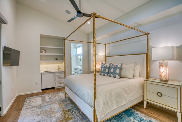 bedroom featuring vaulted ceiling, dark hardwood / wood-style flooring, ceiling fan, and ensuite bathroom