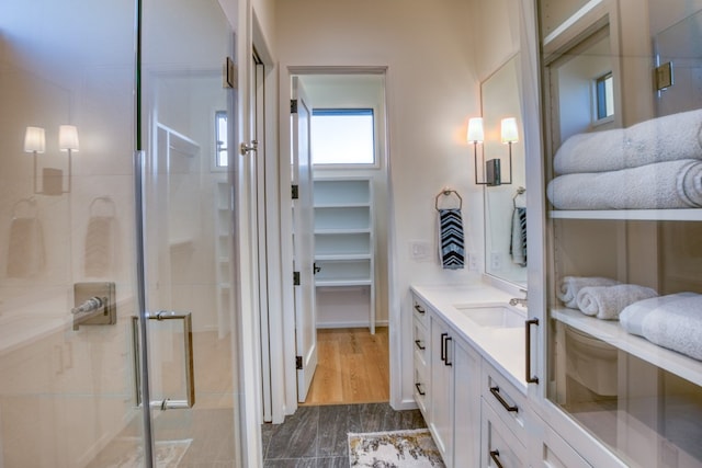 bathroom featuring vanity, a shower with shower door, and hardwood / wood-style flooring