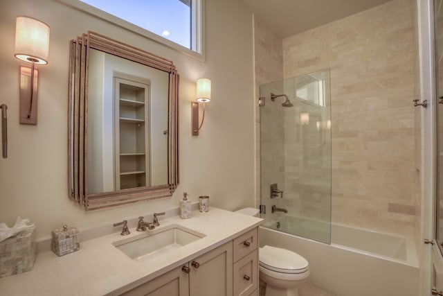 full bathroom with tiled shower / bath combo, vanity, and toilet