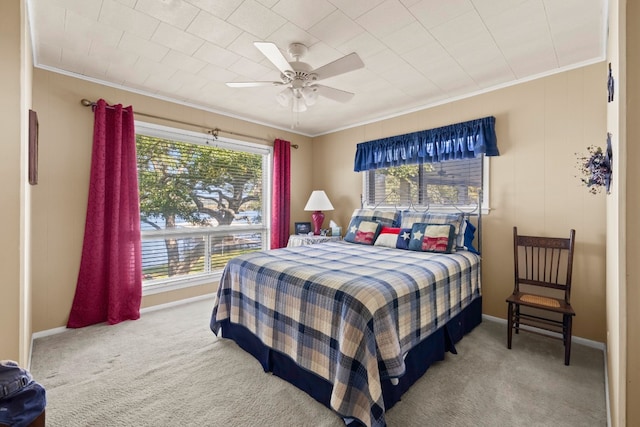 carpeted bedroom featuring ornamental molding, multiple windows, and ceiling fan