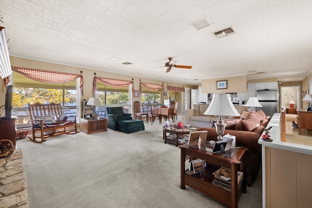 living room with ceiling fan and carpet