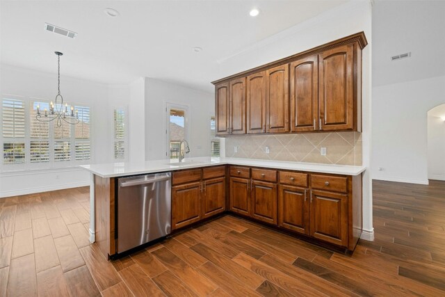 kitchen featuring an inviting chandelier, decorative light fixtures, stainless steel dishwasher, decorative backsplash, and dark hardwood / wood-style flooring