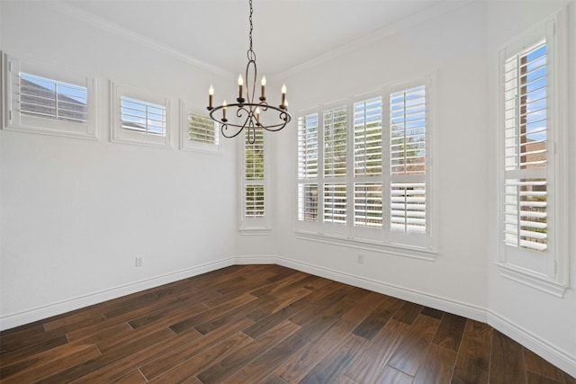 empty room featuring a notable chandelier, crown molding, and dark hardwood / wood-style floors