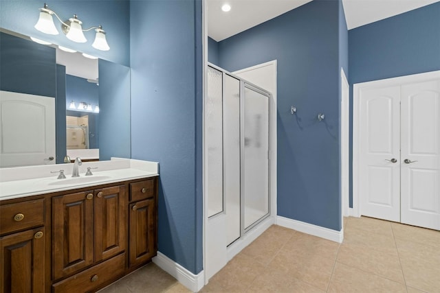 bathroom with a shower with shower door, tile patterned floors, and vanity