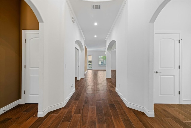 hallway with ornamental molding and dark hardwood / wood-style flooring