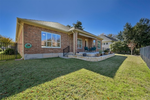 rear view of house with a patio and a yard