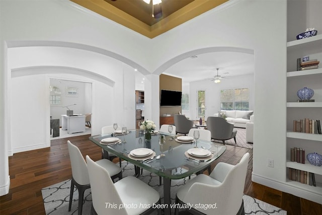 dining area featuring dark hardwood / wood-style flooring, built in features, and ceiling fan